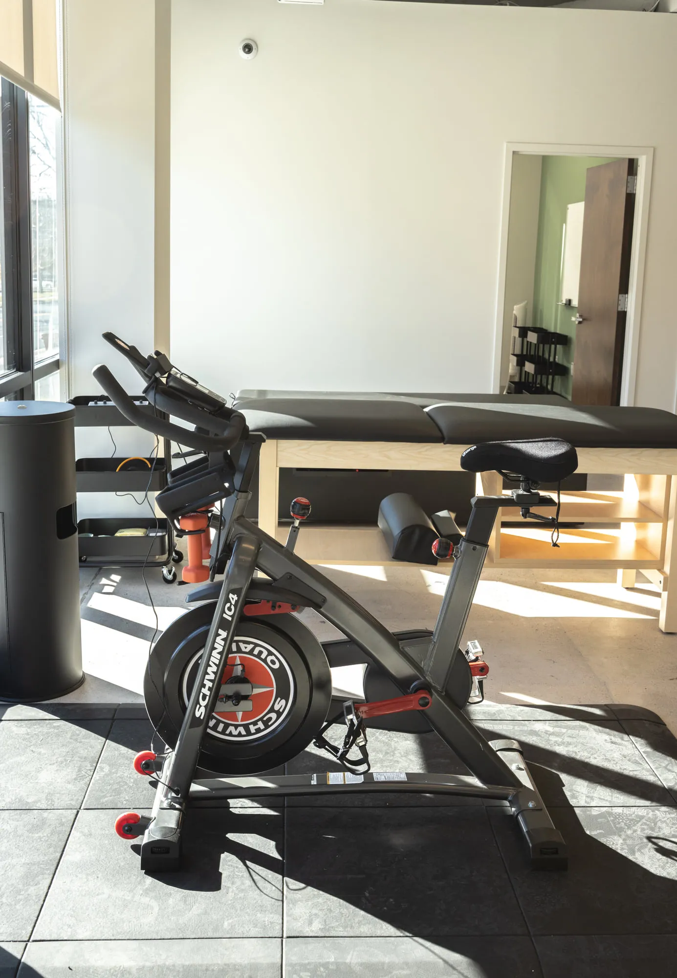 A rehab bike and treatment table in the movement area.