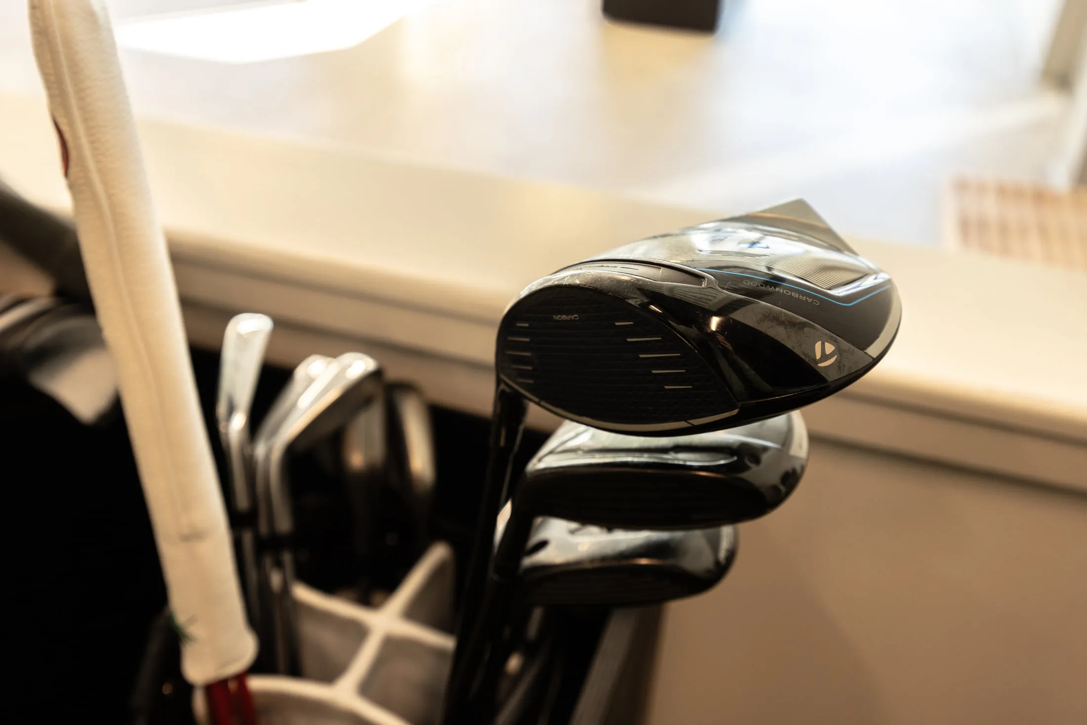 Irons resting against the counter beside the hitting bay at All Square.