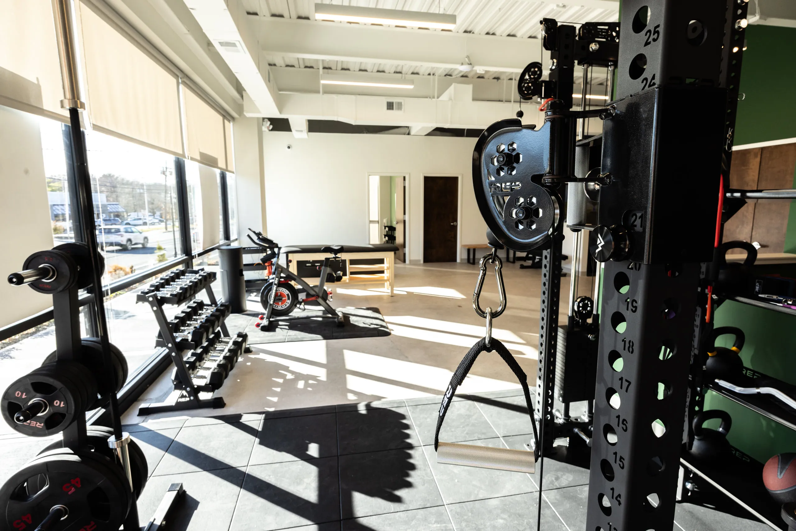 Free weights and training equipment on the performance floor in daylight.